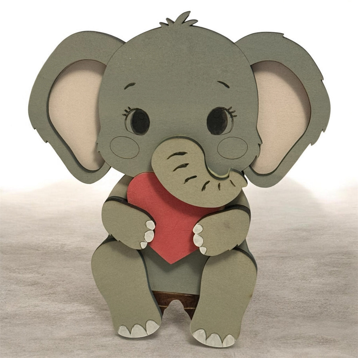 Gray wooden baby elephant shelf sitter holding a red heart